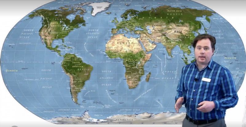 Screenshot of full screen content view with presenter standing in front