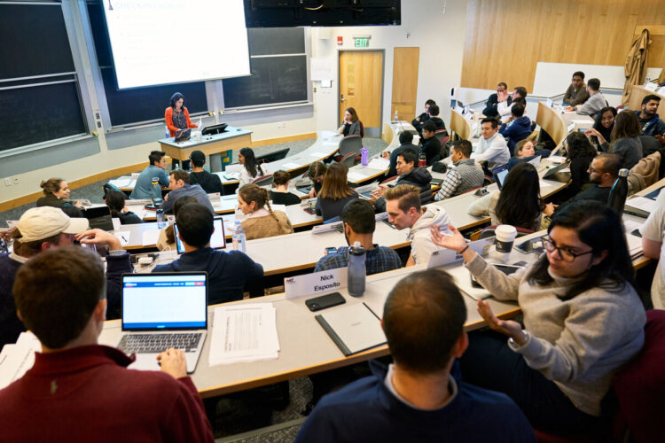 Students talking together in a tiered classroom at MIT Sloan