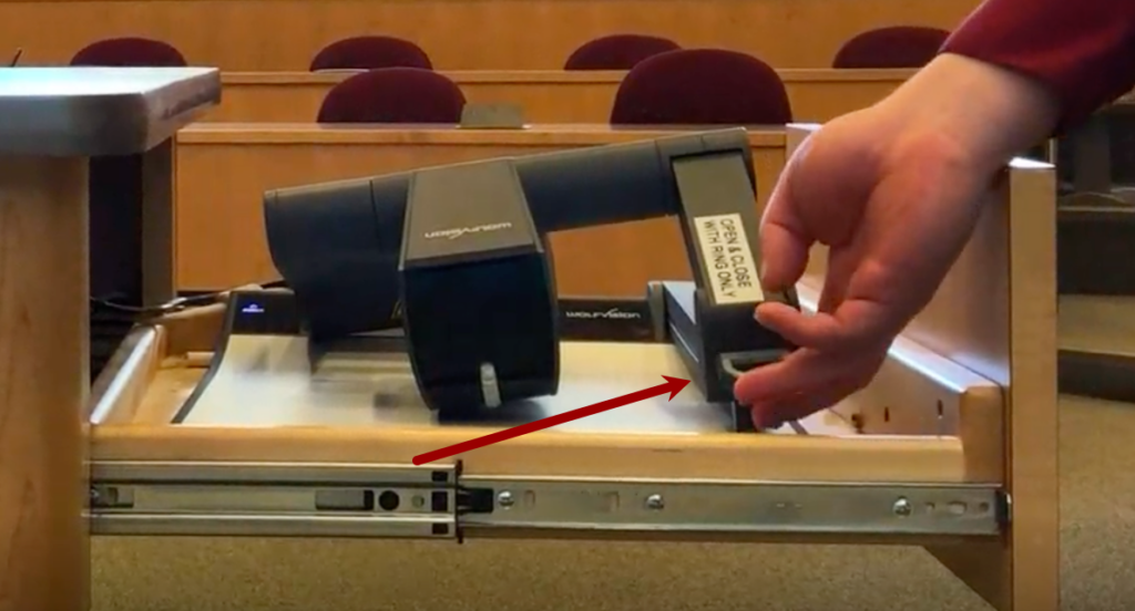 Photo of someone properly lifting the document camera up by the ring