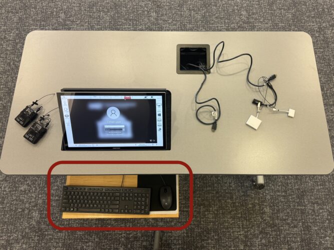 Photo of the classroom teaching table with the keyboard and mouse highlighted